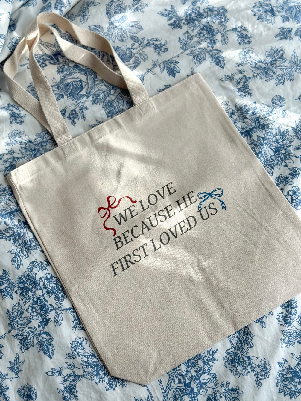 HE FIRST LOVED US Tote Bag